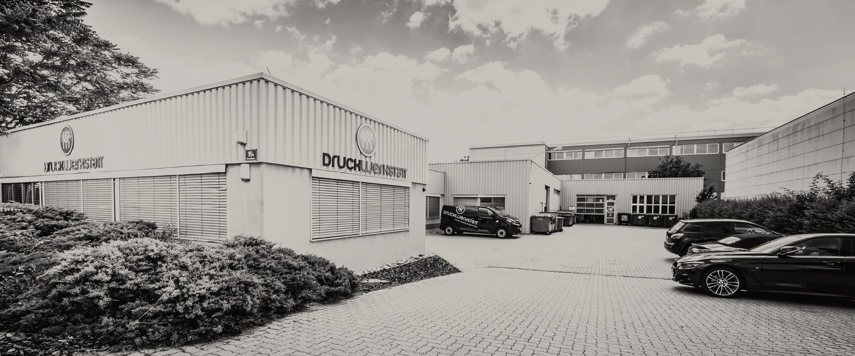 Betriebsgelände der Druckwerkstatt von außen mit Gebäuden
